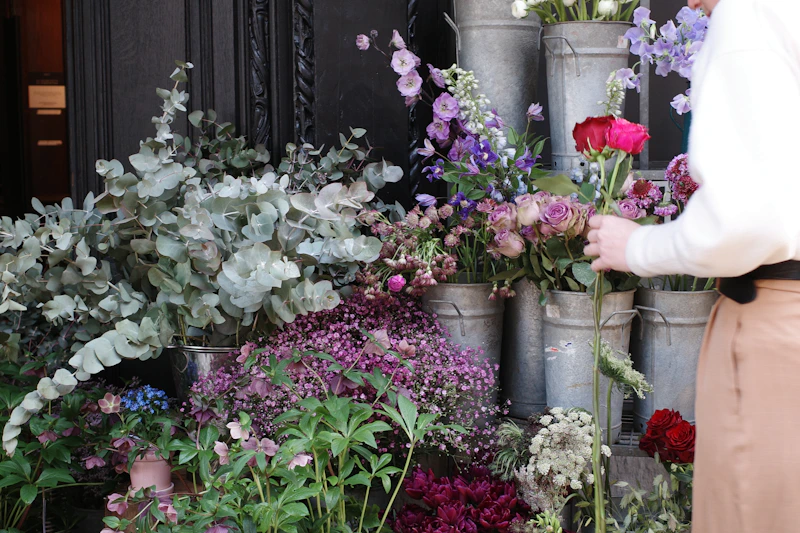 a woman standing next to a bunch of flowers