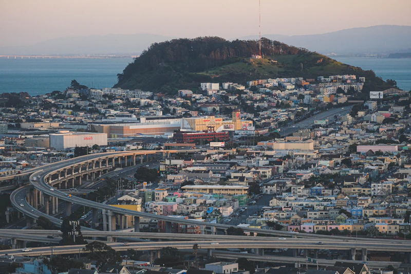 an aerial view of a city with a hill in the background